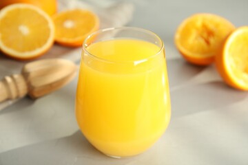 Freshly made juice, oranges and reamer on table, closeup