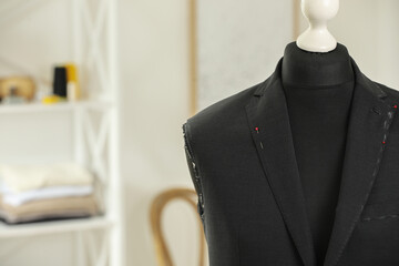 Mannequin with unfinished jacket in tailor shop, closeup. Space for text