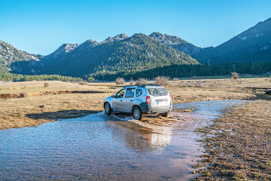Eynif, Antalya, Turkey-February 2, 2024:The suv car is splashing the water in the river  in Eynif plateau,  İbradı, Antalya