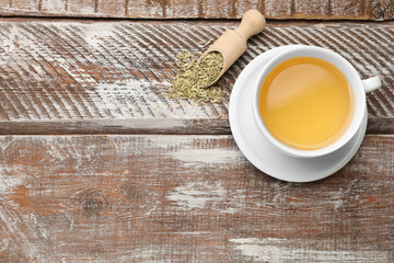 Aromatic fennel tea, seeds and scoop on wooden table, top view. Space for text