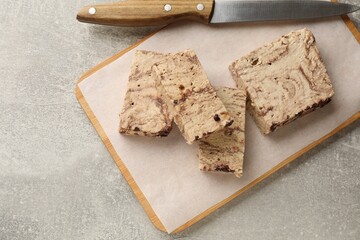 Tasty chocolate halva and knife on grey table, top view. Space for text