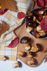 Several Imleria Badia or Boletus badius mushrooms commonly known as the bay bolete and vintage pan with mushrooms on wooden cutting board..