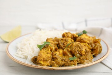 Delicious chicken curry with rice on white wooden table