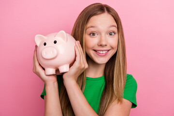 Photo of lovely positive cute girl wear green trendy clothes hold piggy bank collect money for...
