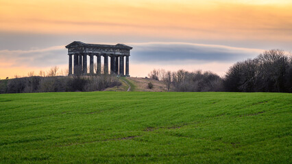Sunset at Penshaw Monument.  Penshaw Monument is a smaller copy of the Greek Temple of Hephaestus in Athens. Erected in 1844 the folly stands 20 metres high and dominates the skyline of Wearside - obrazy, fototapety, plakaty