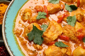Delicious chicken curry with parsley on table, closeup