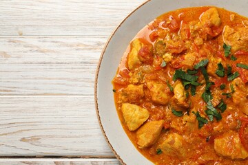 Delicious chicken curry on wooden table, top view. Space for text
