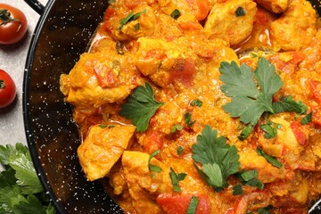 Delicious chicken curry in frying pan on table, top view