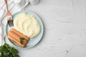 Delicious boiled sausages, mashed potato, parsley and fork on white textured table, top view. Space for text