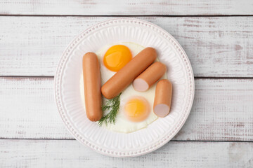 Delicious boiled sausages, fried eggs and dill on wooden table, top view