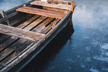 A wooden rowboat on the frozen lake.