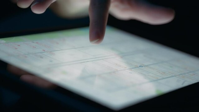 Person searching for a destination on a city map using a tablet. Close up, slow motion. 