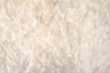 A beige marble surface with a faintly lit upper half and a darker lower half
