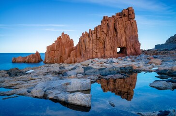 view of the red rocks of Arbatax with reflections in tidal pools in the foreground