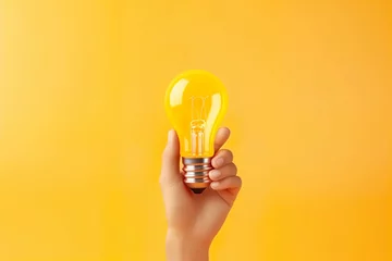 Foto op Aluminium 3d Hand hold light bulb idea thinking or solution business concept icon or symbol on yellow background   © Umar