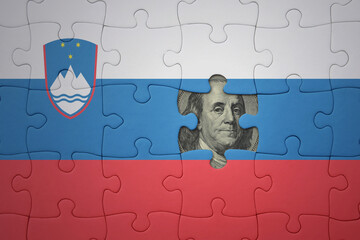 puzzle with the national flag of slovenia and usa dollar banknote. finance concept