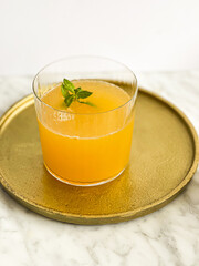 Apricot-flavored water kefir in a glass on a golden plate