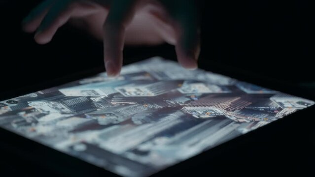 Person exploring satellite 3D view of a city map, looking at buildings. Close up, slow motion. 