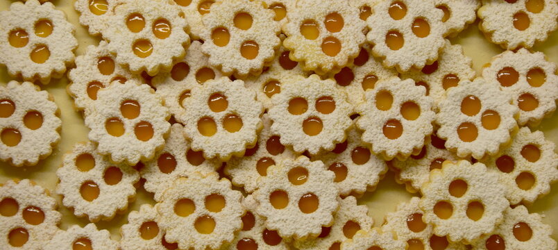 Christmas biscuits baking, rogues, shortcrust pastry biscuits sprinkled with jam and icing sugar, Christmas background	