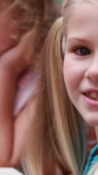 Vertical video of Caucasian girls focused on a task at home