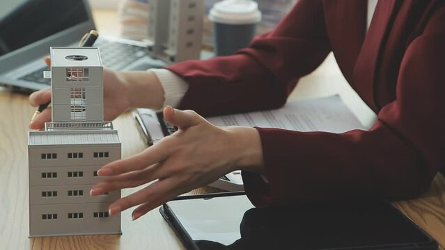 Person Hand Doing Property Tax Calculation Using Calculator Of House Model