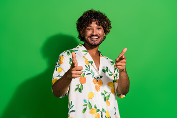 Photo of cool funky arabian man wear print shirt pointing two fingers you isolated green color...
