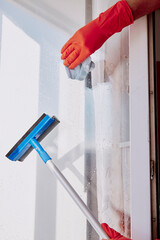 Man hands in rubber gloves is washing windows. Spring cleaning concept. Household chores....