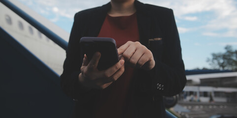 Young asian woman in international airport, using mobile smartphone and checking flight at the...