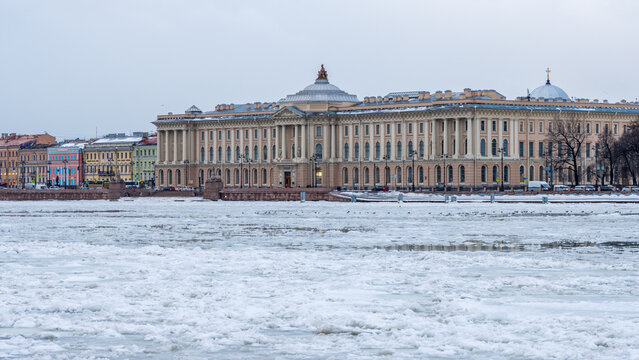 Beautiful winter cityscape. Historic city center of St. Petersburg, Russia. View of the building of the St. Petersburg Academy of Arts named after Ilya Repin. Ice floes on the Neva River. Cold weather
