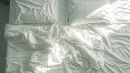 an unmade bed with a white comforter and a white pillow with a white comforter on top of it.
