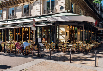 Typical view of the Parisian street with tables of brasserie (cafe) in Paris, France. Cozy cityscape of Paris. Architecture and landmarks of Paris. - 737185577