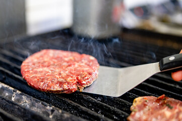 Chef roasts cutlets, meat for burgers in kitchen of restaurant