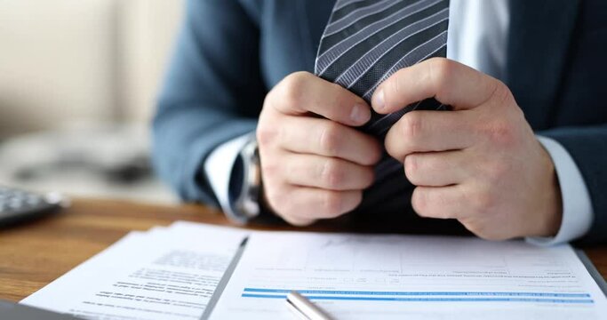 Businessman nervously crumples tie. Psychological approaches in business and depressive burnout concept
