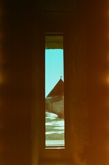 View of the old fortress through a narrow window - film photo with backlighting