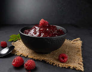 raspberry jam in a black bowl on eco fabric, product photography, food, restaurant, macro, black background