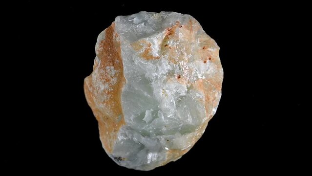 Prehnite (inosilicate of calcium and aluminium with the formula Ca2Al2) nodule rotating slowly against a black background.	