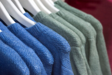closeup of colorful woolen pullover on hangers in a woman fashion store showroom	 - 737193508