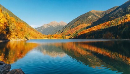 mountainous autumn landscape with lake in evening light scenery in fall colors reflecting in the calm water local tourism and relaxation concept