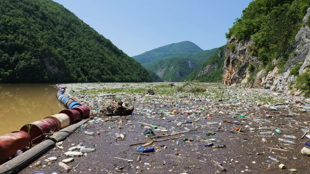 Garbage floating on the Drina river in Bosnia and Herzegovina. Plastic waste and river pollution. Island of garbage. Environmental issue. Take action to protect the planet.