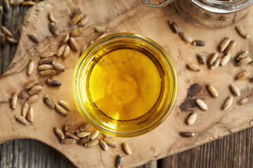 Obraz na płótnie Canvas Milk thistle oil in a glass bowl with Carduus marianus seeds