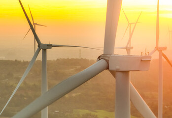 Wind farm field and sunset sky. Wind power. Sustainable, renewable energy. Wind turbines generate...