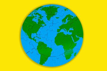 World Map Puzzle: Green Continents and Blue Oceans on Yellow Background