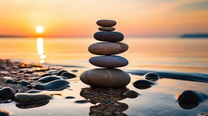 Foto op Aluminium balance stack of zen stones on beach during an emotional and peaceful sunset, golden hour on the beach © Zainab