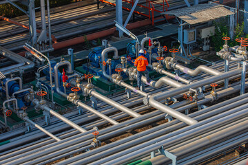 Male worker inspection at steel long pipes and pipe elbow in station oil factory during refinery...