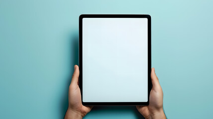 Hands holding tablet computer with blank white screen on blue background
