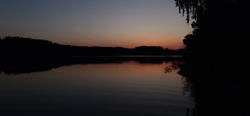 A freshwater reservoir at sunset is a captivating scene where the sun descends below the horizon,...