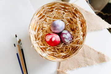 Fototapeta na wymiar Colorful Easter eggs in basket. Happy Easter! Happy family painting eggs for Easter celebration.