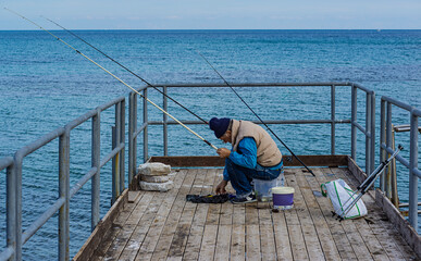 fisherman fishing from the pier of a beach