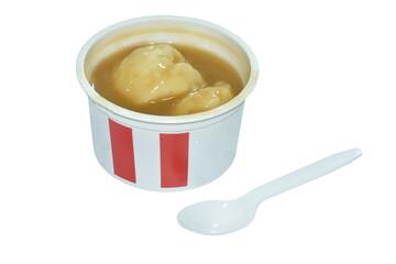 mashed potato dressing gravy sauce with plastic spoon in cup on white background