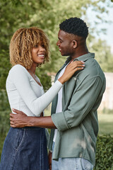 Obraz premium happy african american couple holding hands and hugging each other outdoors, woman in braces